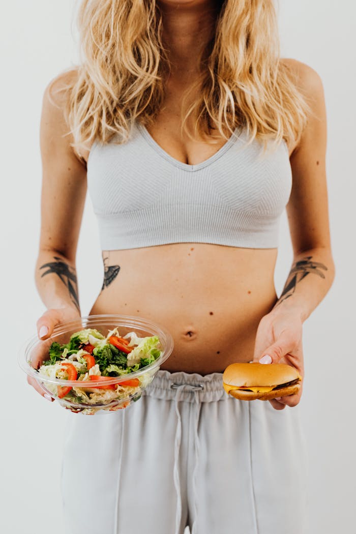 A woman deciding between a healthy salad and a burger, symbolizing diet and lifestyle choice.