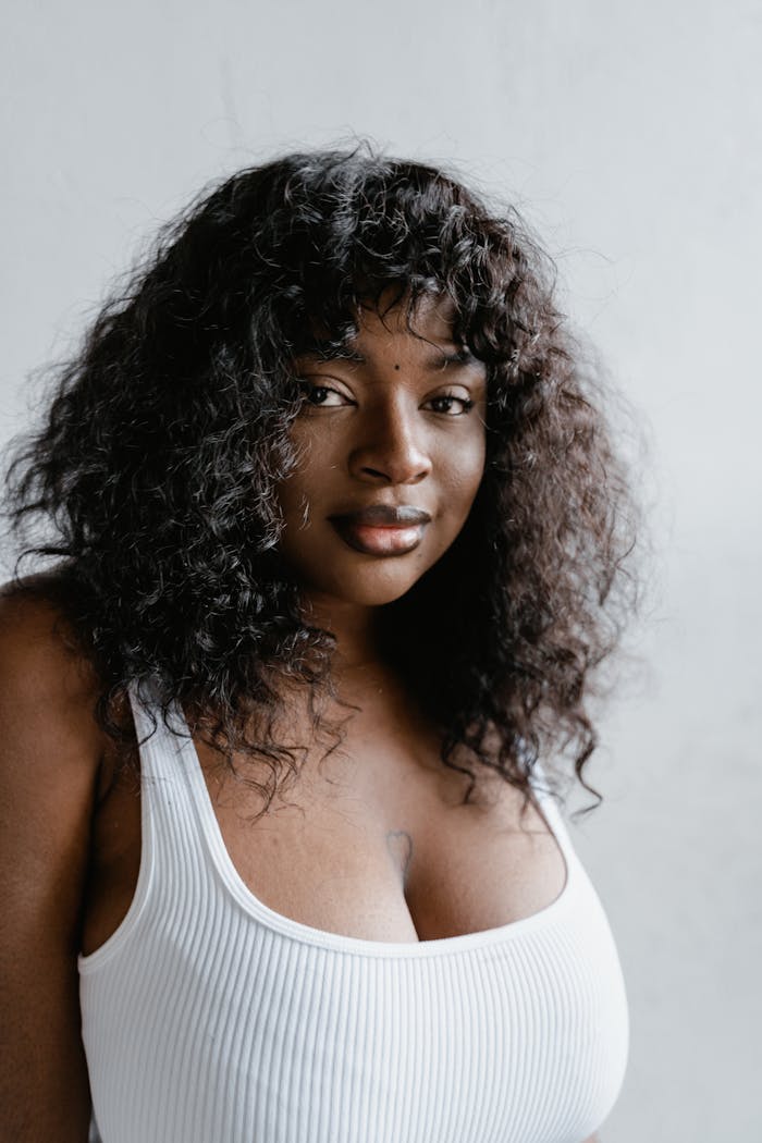 Portrait of a confident afro-American woman in a studio with natural lighting, expressing self-assurance and beauty.